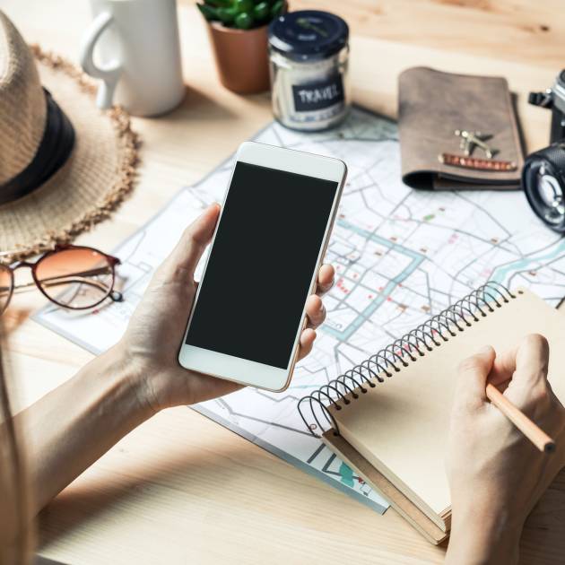 Young women traveler planning vacation trip and searching information or booking the hotel on a smart phone